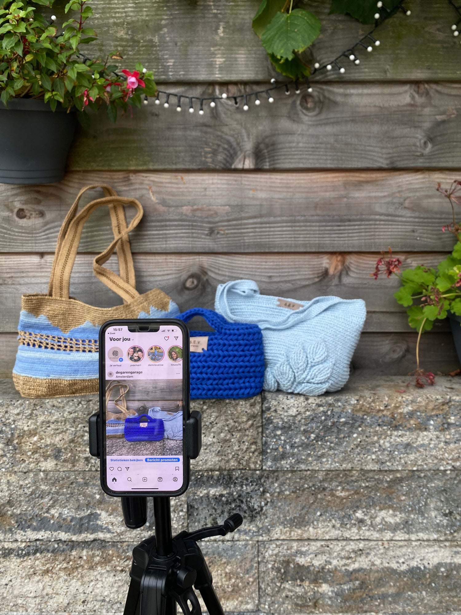 Een telefoon in een standaard met op de achtergrond drie tassen